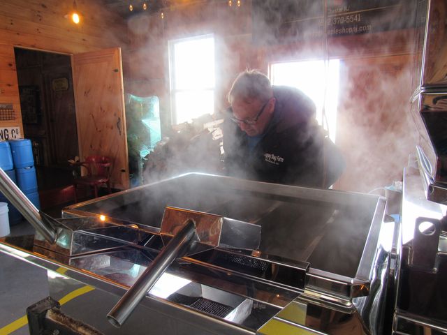 Farmer Tim Stockel inspects the finishing pan inside an evaporator at his sugarhouse in Manalapan, New Jersey, February 20, 2022.
